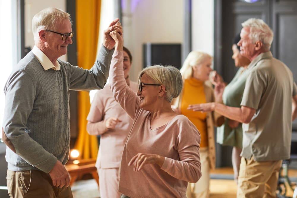 Elderly people dancing in an aged care facility